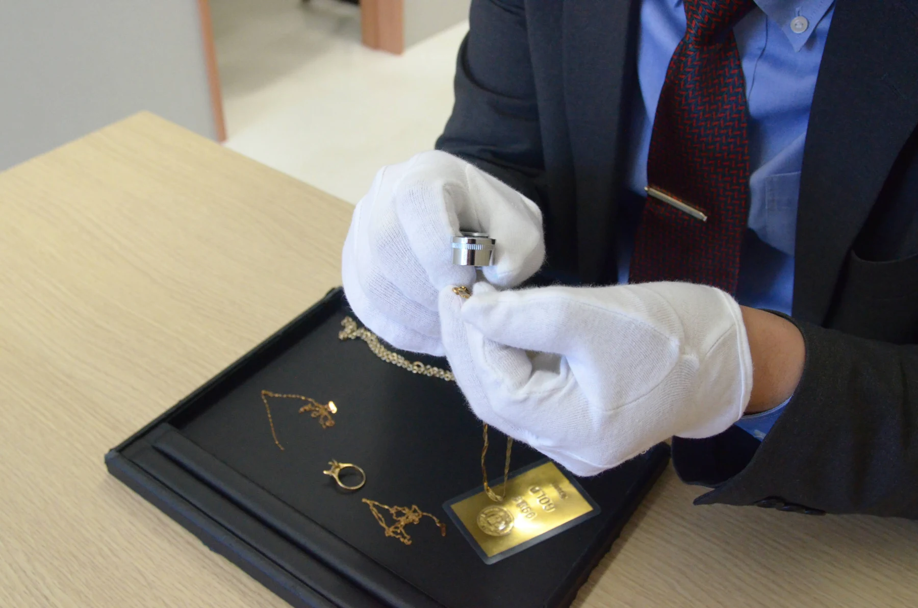 手袋を着用し、貴金属の素材や状態を確認する査定風景